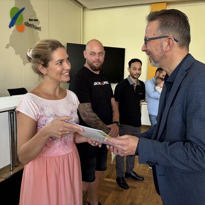 Landrat Alexander Tönnies überreicht Einbürgerungsurkunden.