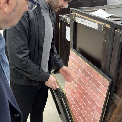 Milan Diebecker zeigt Alexander Tönnies die verschieden bedruckten Dibondplatten.