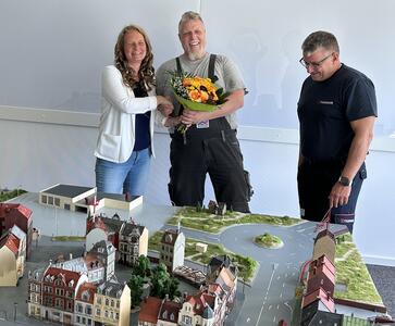 Katja Hermann, Dezernentin für Service, Mobilität und Sicherheit, und Kreisbrandmeister Gerd Ritter danken Modellbauer Thomas Noerenberg für die Planspielplatten.