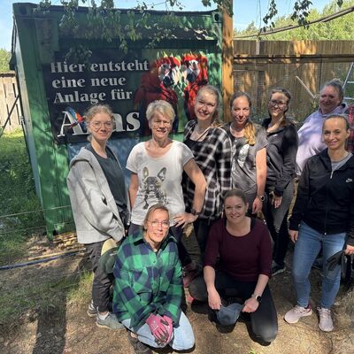 10 Personen stehen vor einem großen Schild. Darauf steht: "Hier entsteht eine neue Anlage für Aras".