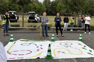 Zwei Frauen stehen vor zwei bemalten Leinentüchern. 