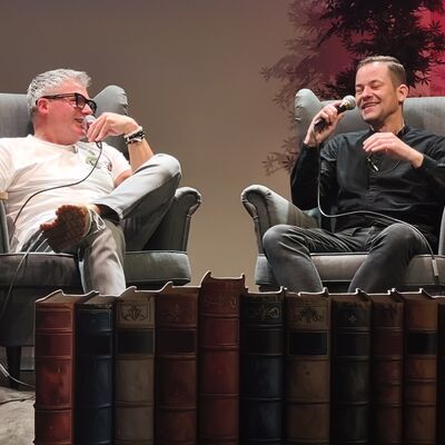 Der Autor Andreas Winkelmann und der Moderator Vincent Kliesch sitzen in zwei Sesseln auf der Bühne und führen im Anschluss an die Lesung ein lockeres Gespräch zum Buch.