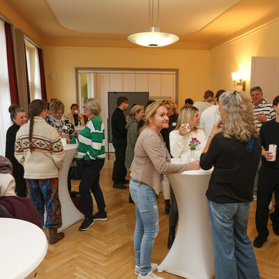 Teilnehmerinnen und Teilnehmer der 3. Kinder- und Jugend-Gesundheitskonferenz des Landkreises Oberhavel im Gespr&auml;ch an Stehtischen w&auml;hrend einer Pause zwischen den Fachvortr&auml;gen.
