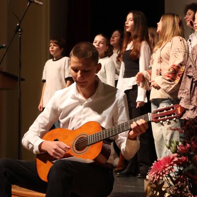 Jungen und Mädchen im Chor auf einer Bühne.