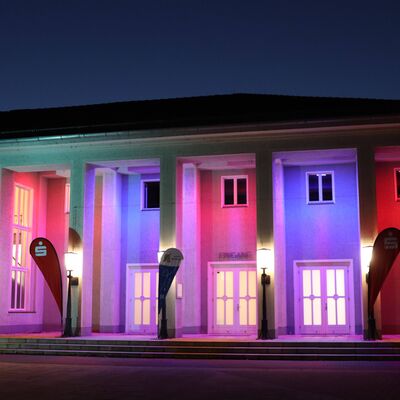 Das beleuchtete Stadtklubhaus Hennigsdorf am Abend.