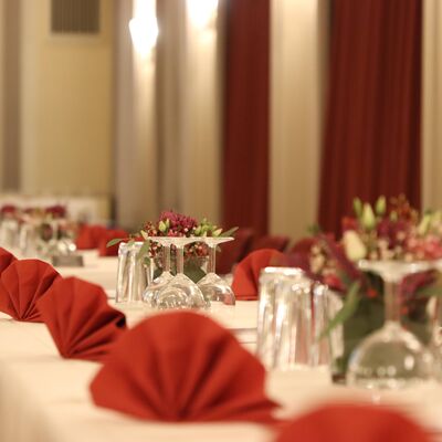 Gedeckte Festtafel mit Servietten und Blumen.