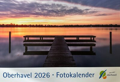 Bild eines Stegs an einem See bei Sonnenaufgang. In blauer Schrift steht unterhalb des Bildes: Oberhavel 2026 Fotokalender. Rechts daneben das offizielle Logo vom Landkreis Oberhavel. 