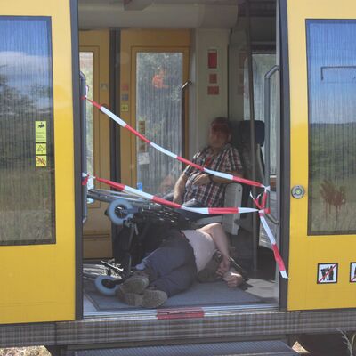 Verletzte und gest&uuml;rzte Bahnreisende im Zug durch den simulierten Unfall im &Uuml;bungsabschnitt MANV. Absperrband zur Simulation einer nicht  nutzbaren Zugt&uuml;r. Flecken von Kunstblut f&uuml;r eine realit&auml;tsnahe Darstellung.
