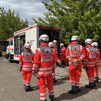 Kr&auml;fte der Schnelleinsatzeinheit Sanit&auml;t bei der Entladung von Ausstattung und Material aus dem Ger&auml;tewagen, zum weiteren Aufbau hin zur medizinischen Versorgung der simulierten Verletzten im &Uuml;bungsabschnitt MANV.