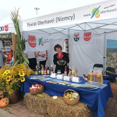 Eine Frau steht hinter dem Messestand und h&auml;lt eine Melone in der Hand.