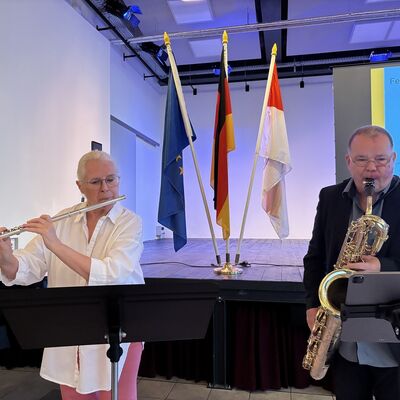 Ein Mann am Saxophon und eine Frau mit Querfl&ouml;te muszieren gemeinsam.