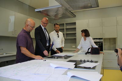 Landrat Ludger Weskamp l&auml;sst sich die Funktionen in der Lehrk&uuml;che der Regenbogenschule erkl&auml;ren. 