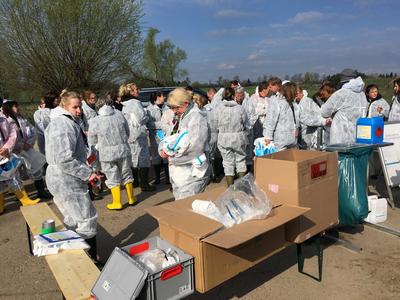 Die Teilnehmer der Landestierseuchen&uuml;bung 2019 legen ihre Schutzanz&uuml;ge an.