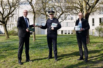 Landrat Ludger Weskamp und Verwaltungsstab-Leiter Matthias Rink übergeben Mund-Nasenschutz-Masken an Polizeirat Hendrik Jenke, Stellvertretender Leiter der Polizeiinspektion Oberhavel.